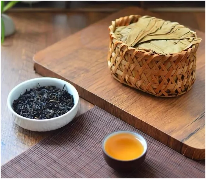 Ancha basket with loose leaves in a white bowl and a small tea cup