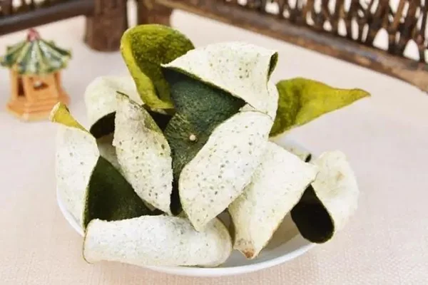 Green citrus peel pieces showing their pale inner surface