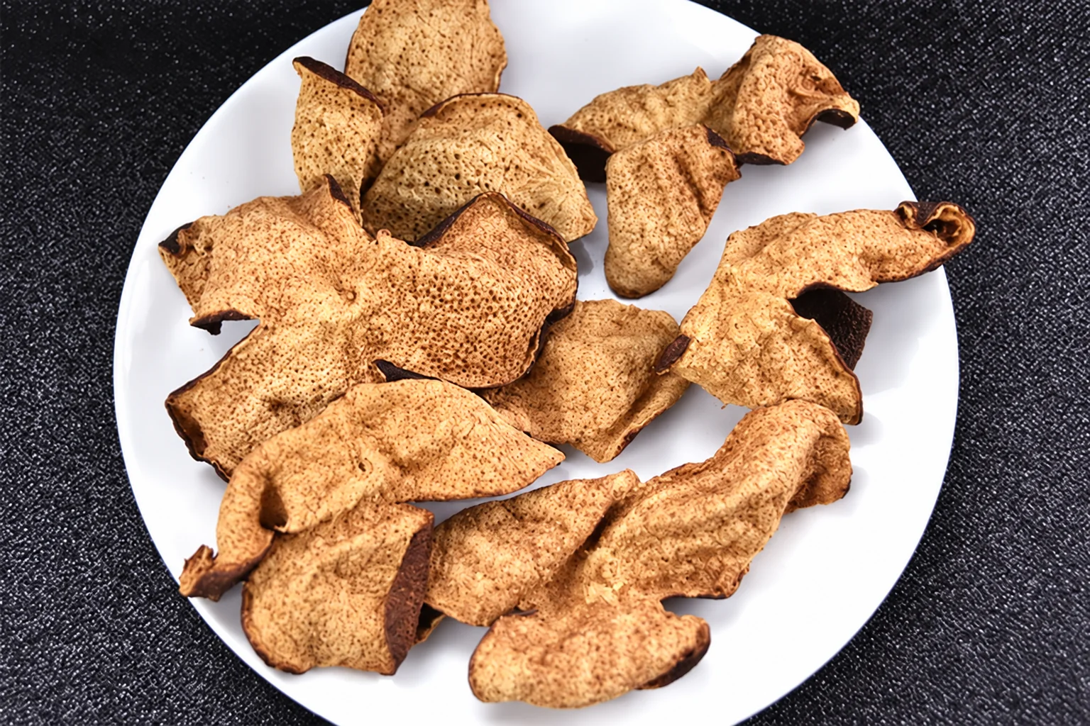 Assorted dried peel pieces on a white plate