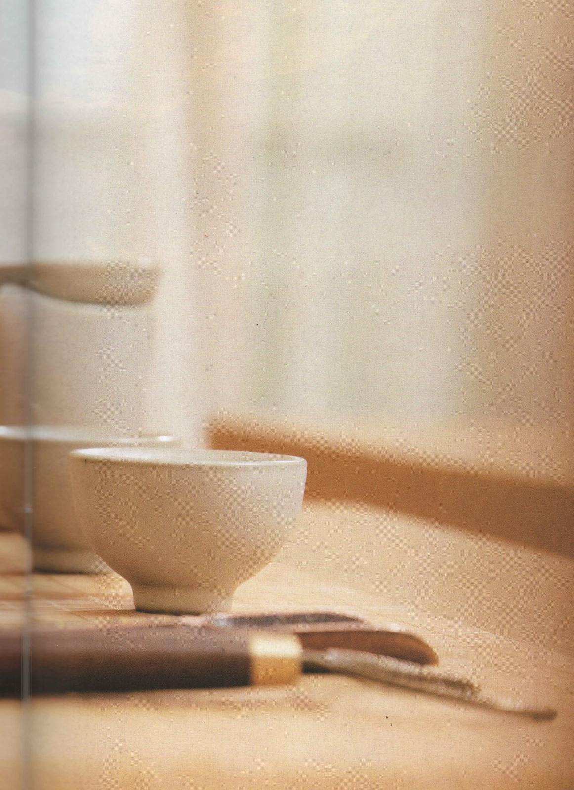 Pale ceramic tea cup on a wooden tea table