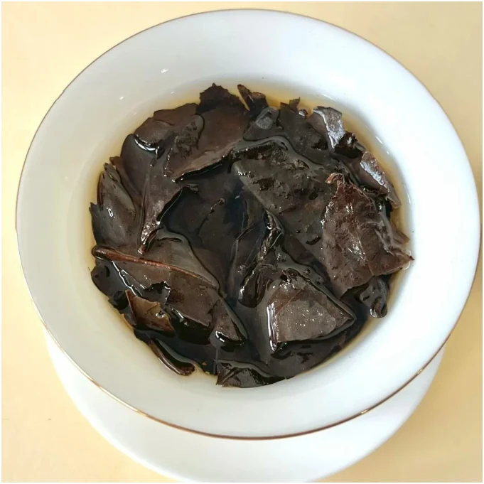 Coarse mature infused tea leaves in a white bowl