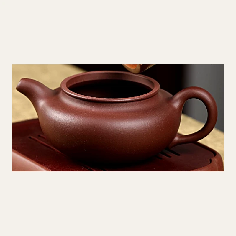 Open Fanggu teapot showing its wide mouth and handle