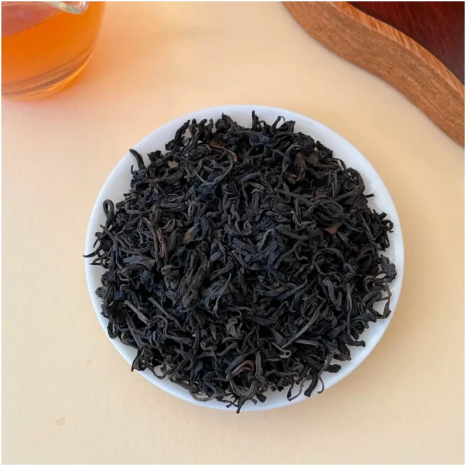 Fine dry dark tea leaves in a white dish