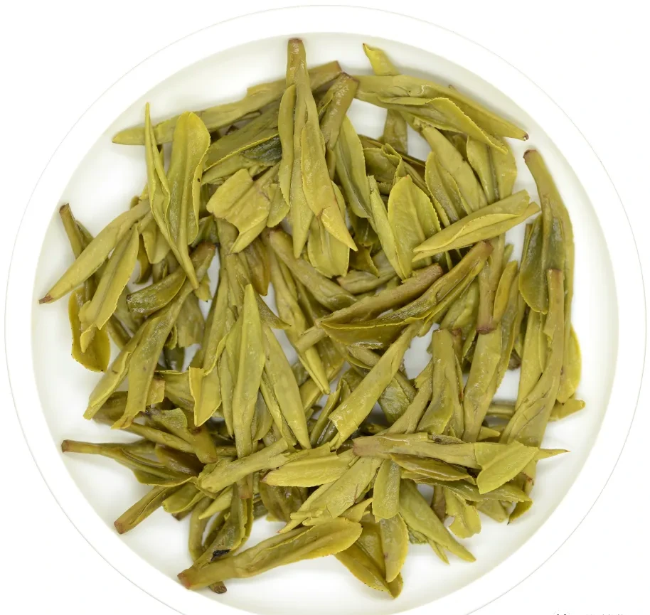 Opened green leaves in a white dish after brewing the Gelong sample