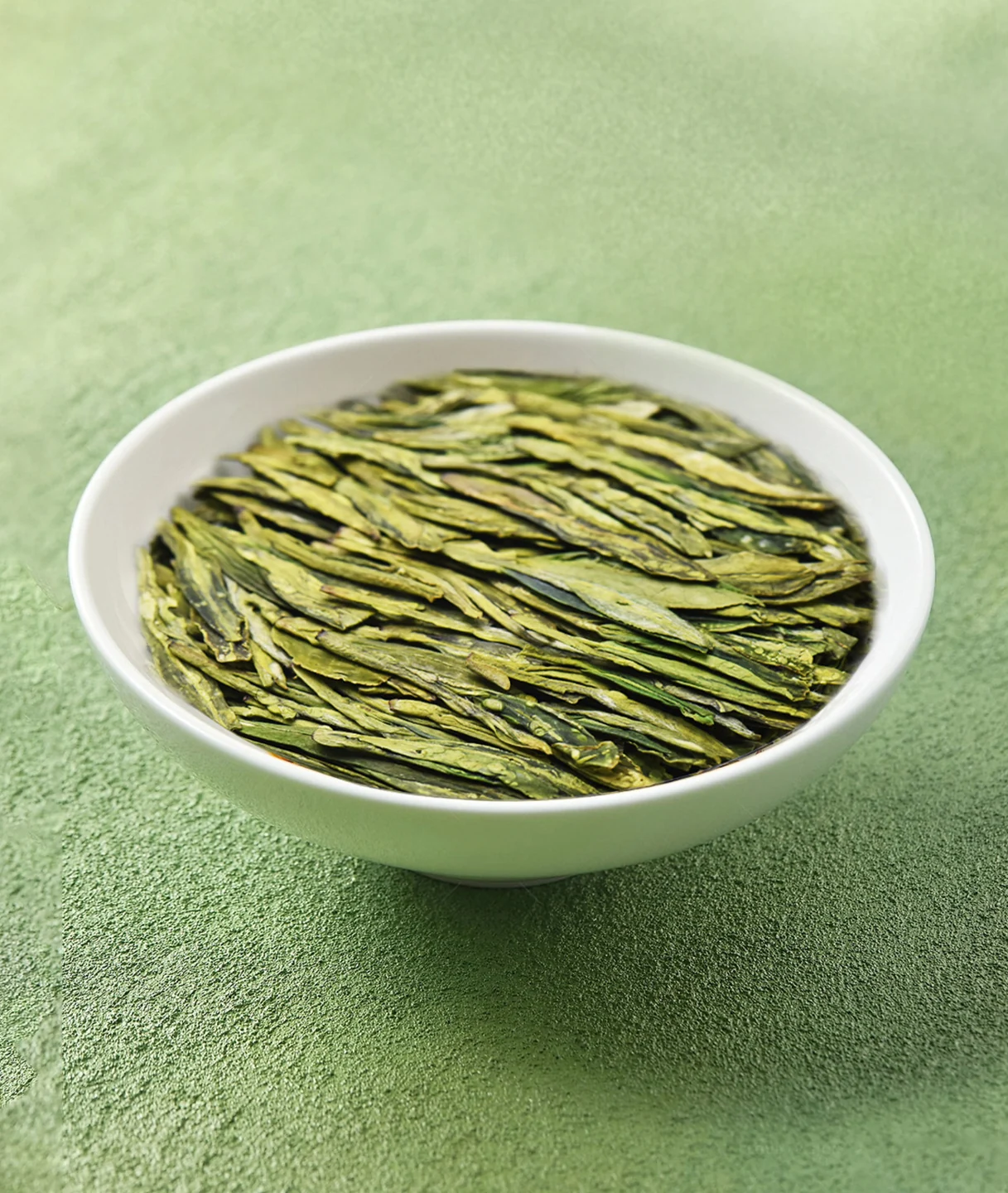 Flat dry leaves of Gong Pai Longjing green tea