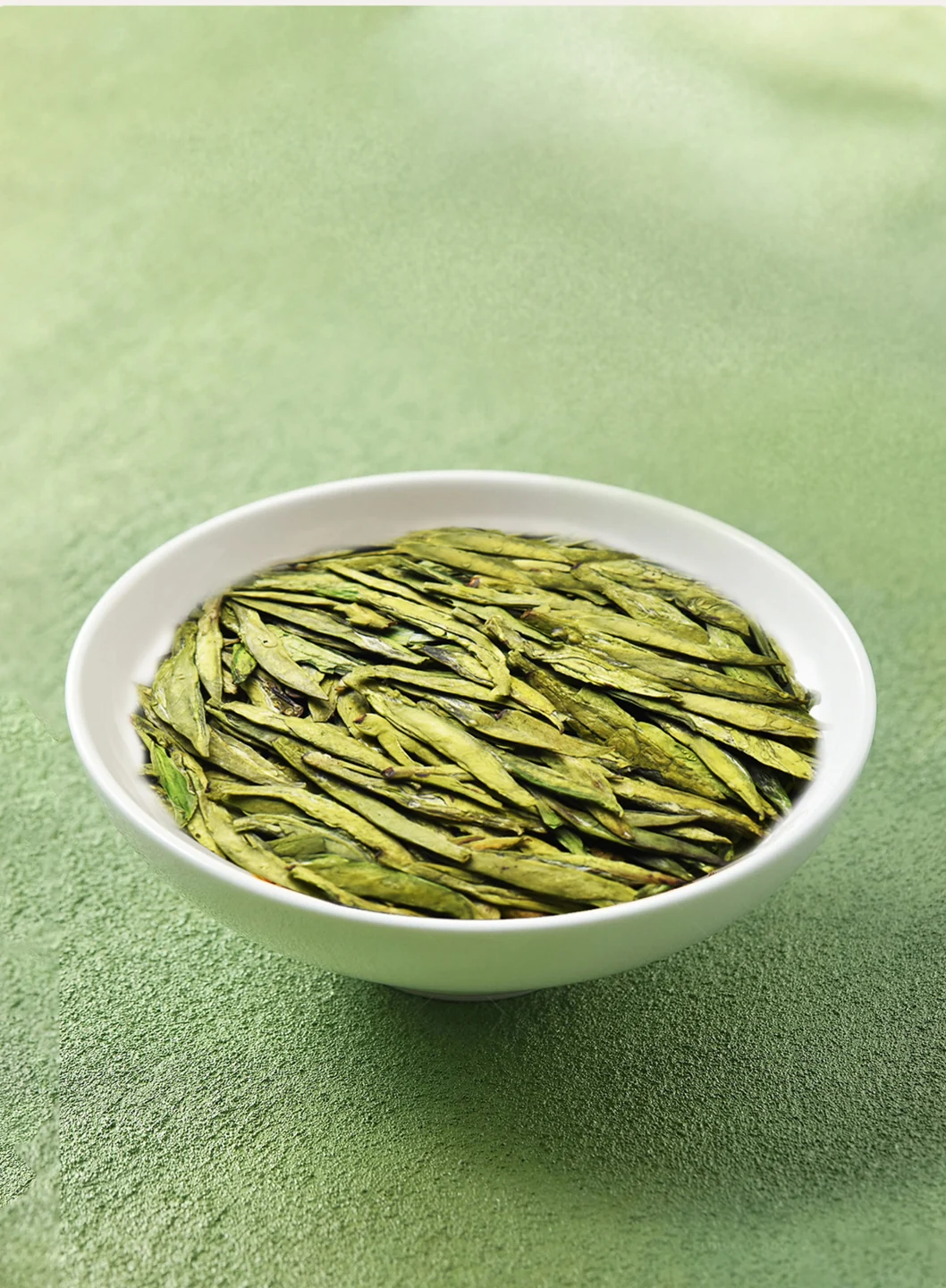 Flat dry leaves of Gong Pai Longjing green tea