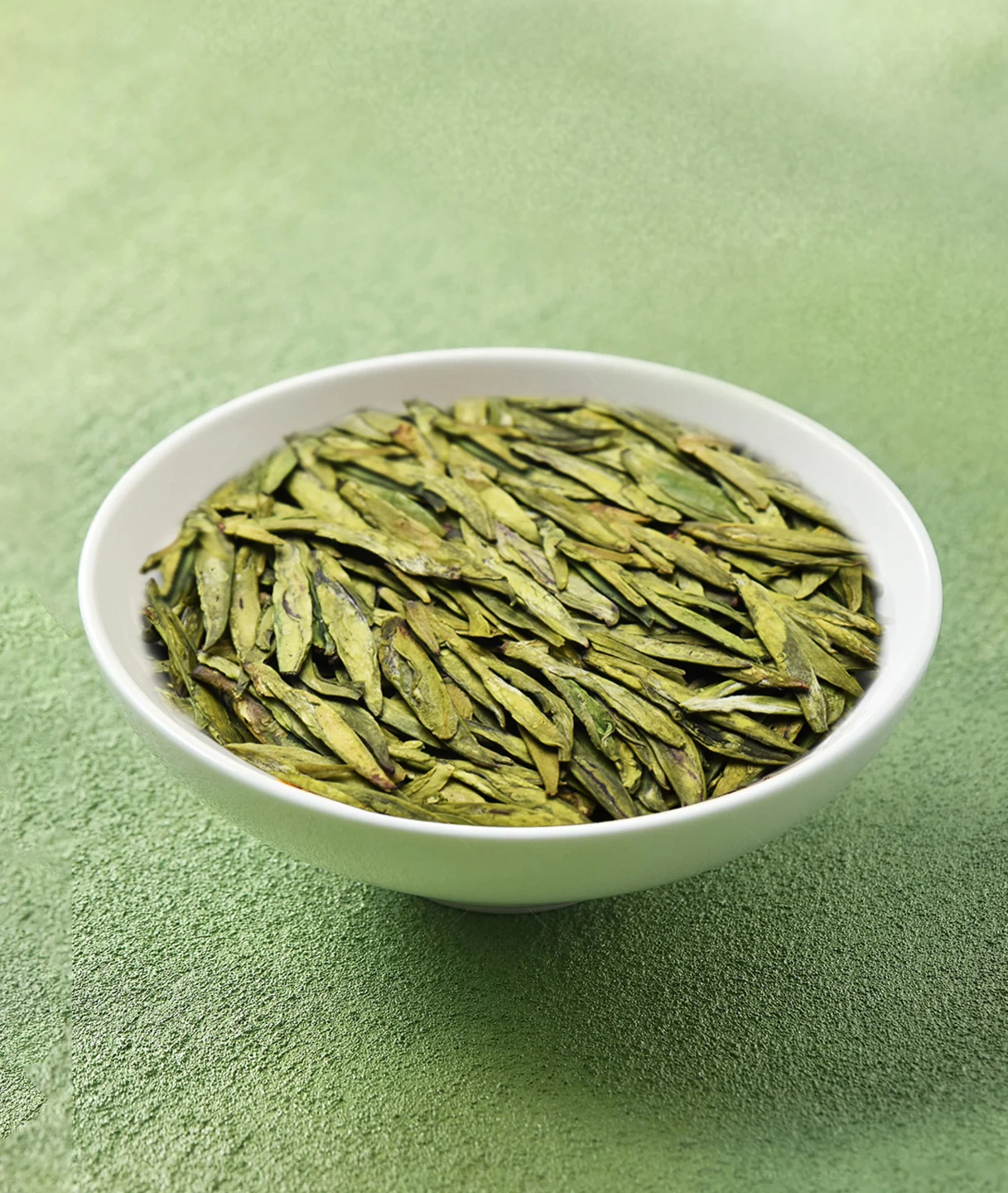 Flat dry leaves of Gong Pai Longjing green tea