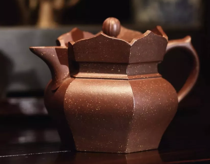Faceted brown teapot with a crown-shaped monk-cap rim and pale clay inclusions