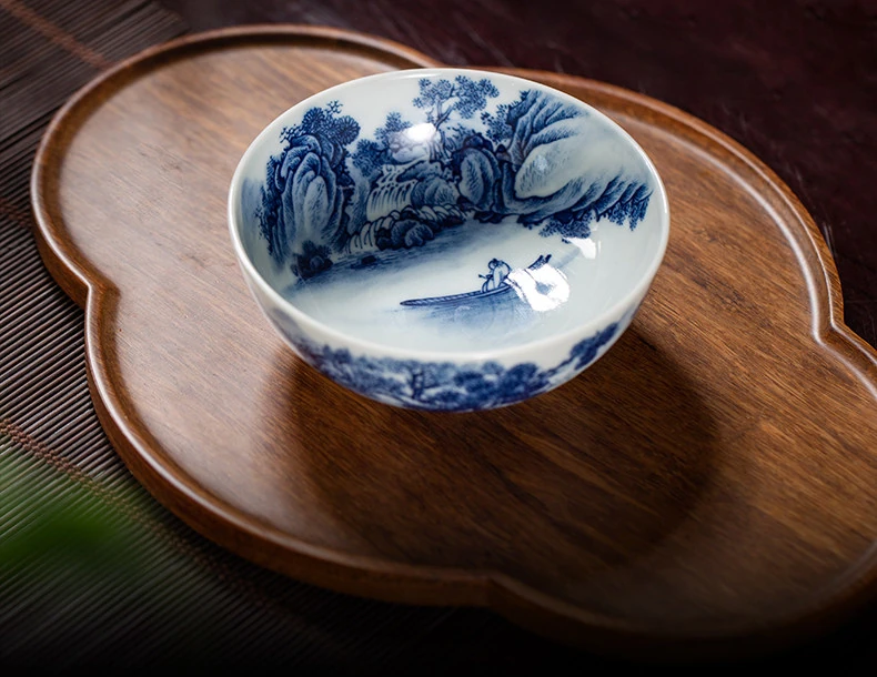 Open landscape teacup on a wooden tray with the boat scene visible inside
