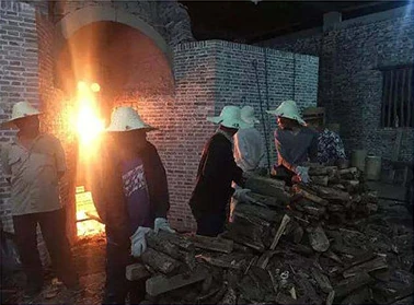 Workers tending the kiln during wood firing