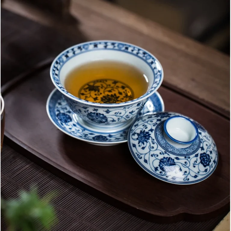 Blue and white lotus gaiwan filled with tea, with lid beside the bowl