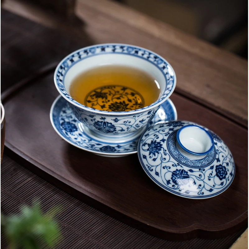 Blue and white lotus gaiwan filled with tea, with lid beside the bowl
