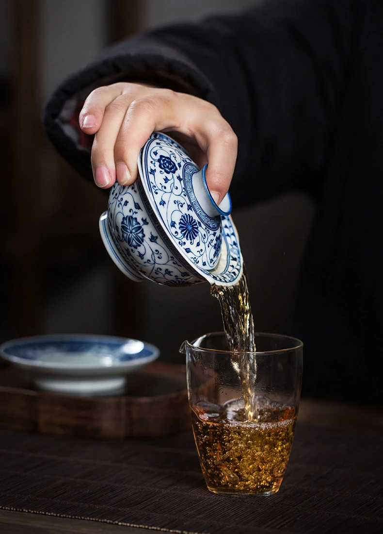 Gaiwan pouring tea into a glass serving pitcher