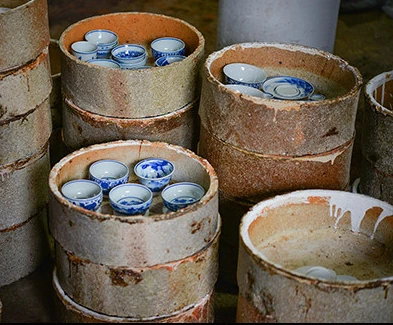 Ceramic vessels stacked in protective kiln saggars