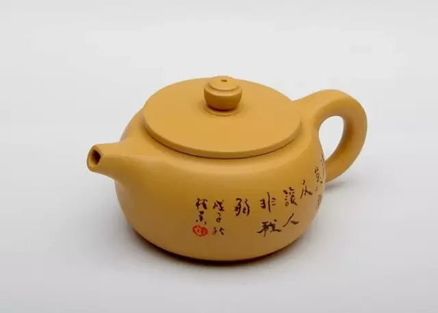 Généralement jaune doré, cylindrique, argile théière avec un couvercle plat et une calligraphie gravée.