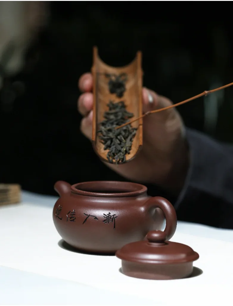 Tea being added to the open Jian Ru Jia Jing teapot