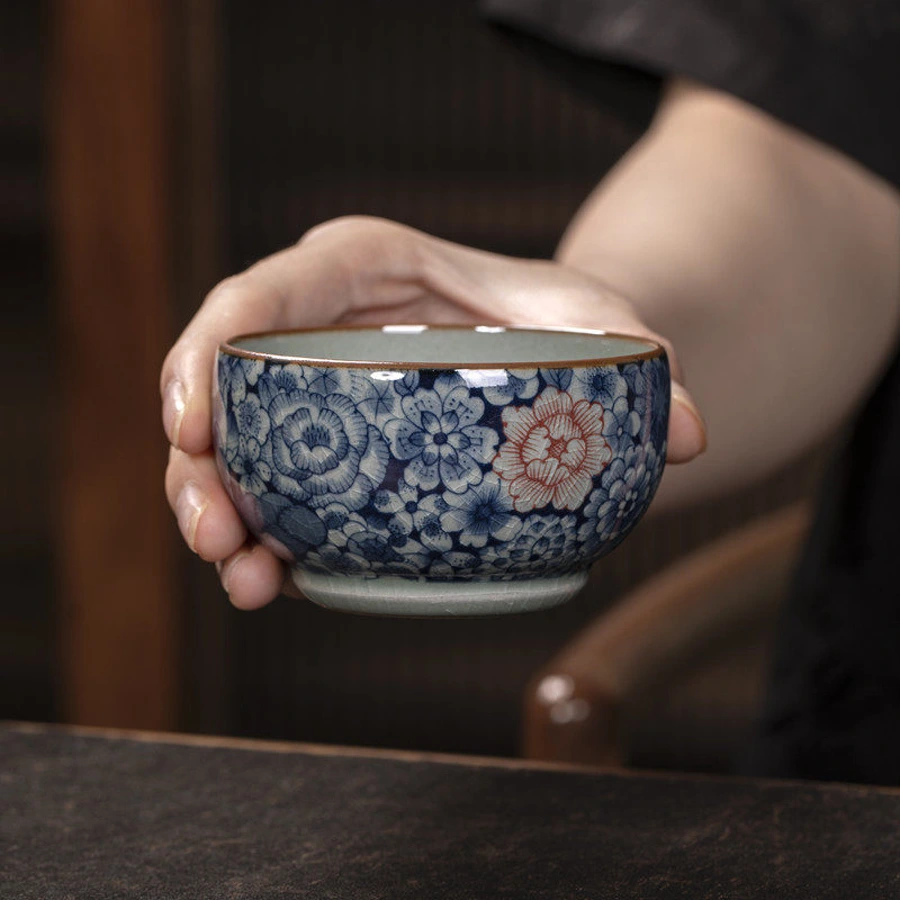 Front view of the Jingdezhen millefleurs teacup with blue flowers and a red outlined blossom