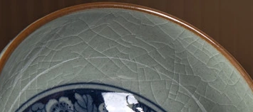 Pale grey-green crackle glaze inside the warm brown rim