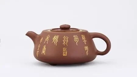 Vue frontale d'un Jinglan de petite taille Yixing théière avec calligraphie dorée