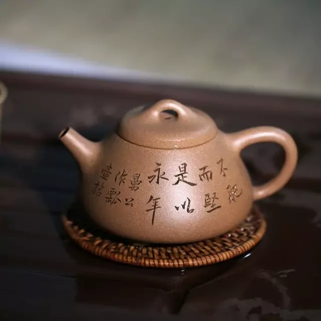 Couleur marron clair, arrondie argile théière avec une calligraphie chinoise gravée