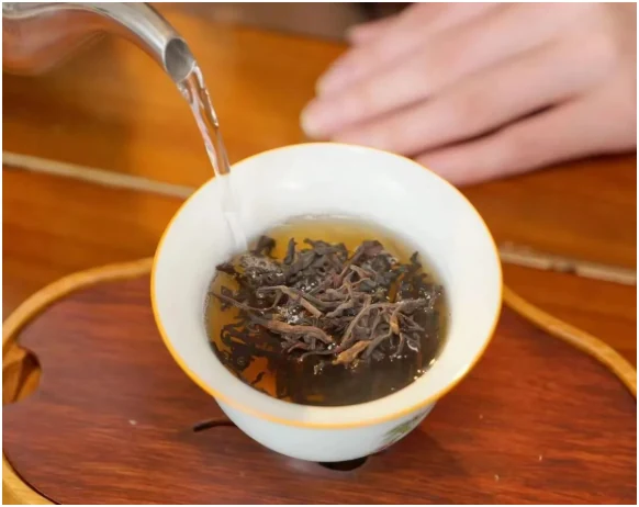 Liubao tea being infused in a white porcelain gaiwan