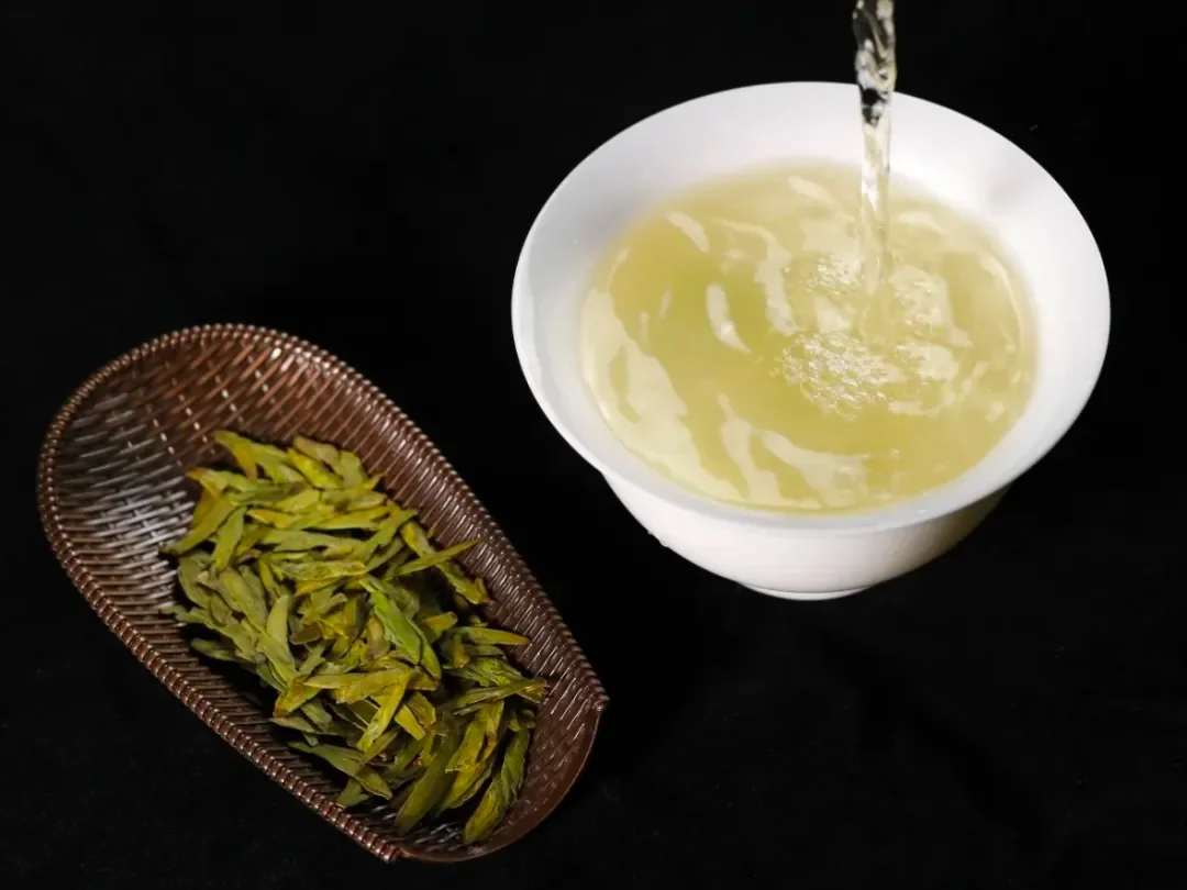 Water poured into a white bowl beside dry tea