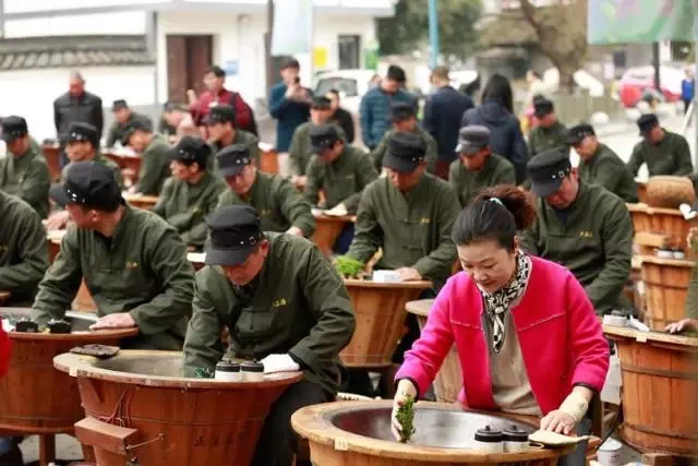 Lu Jiangmei beside tea makers at their pan-firing stations in the supplied profile.