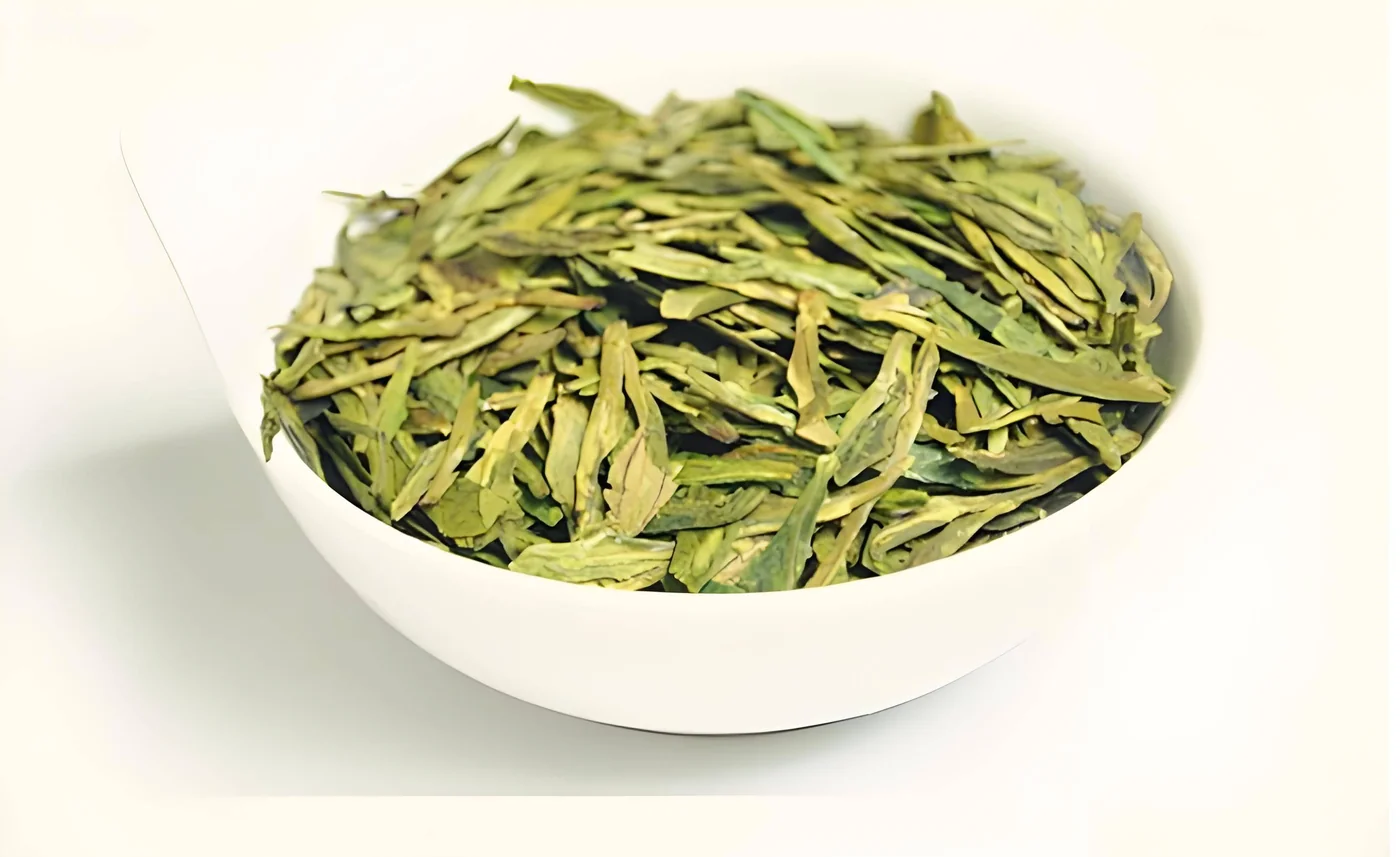 A white bowl of flat Longjing tea leaves