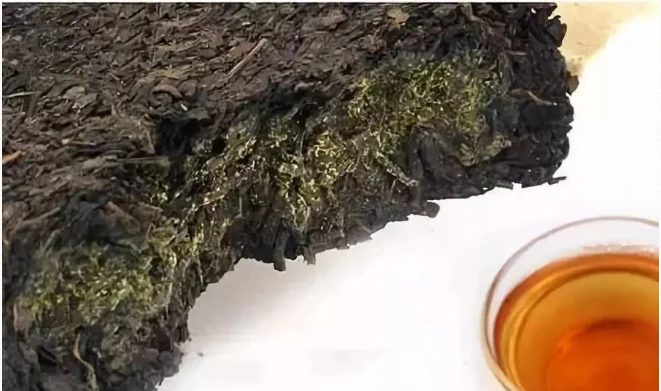 Opened Fu brick tea beside a white tea cup