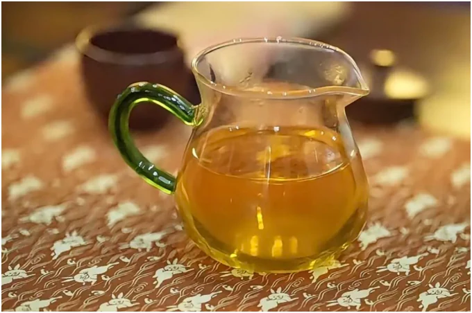 Pale golden Liubao tea in a glass fairness pitcher