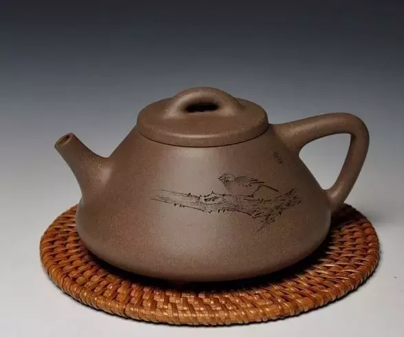 Profil triangulaire gris-brun argile théière avec un bouton percé et un motif paysager gravé