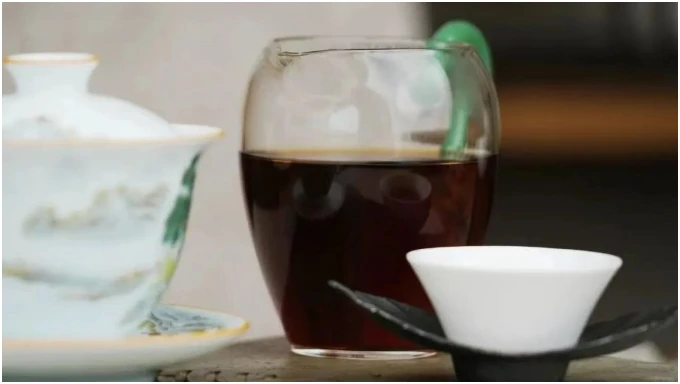 Dark ripe Pu-erh liquor in a clear glass pitcher