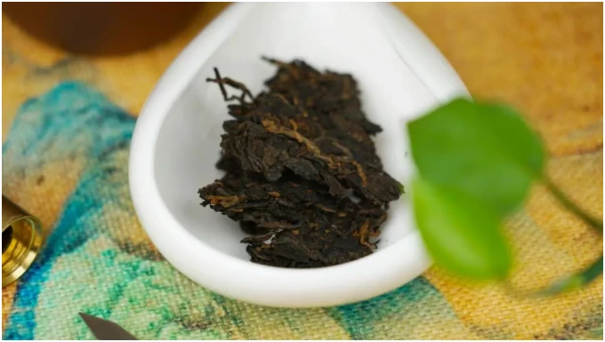 A portion of dark compressed tea in a white dish