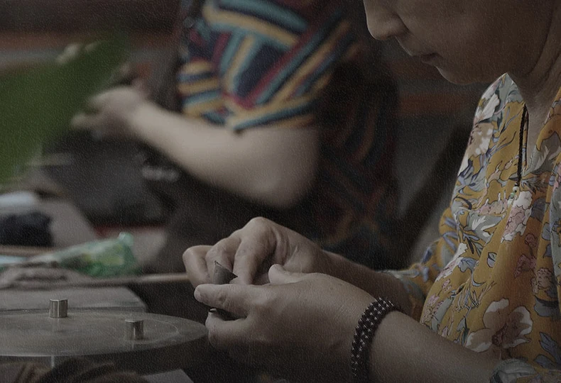 A craftsperson working with Yixing clay at a workshop table