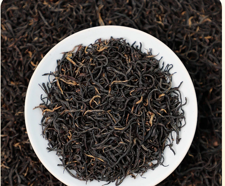 Close view of twisted Keemun Maofeng dry tea leaves and golden tips