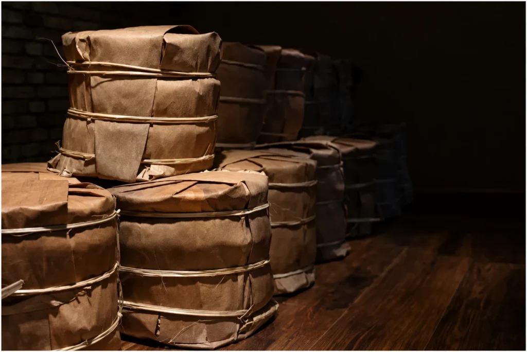 Plain paper-wrapped tea bundles stacked on a wooden surface