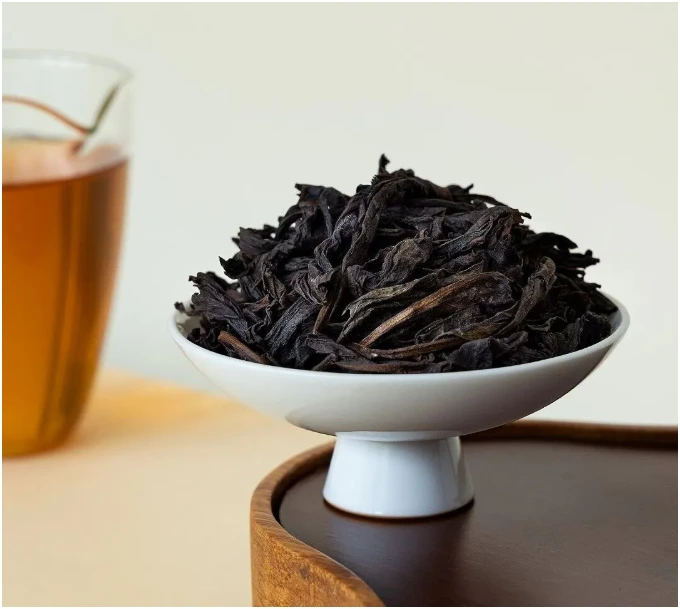 Wuyi rock tea leaves in a white pedestal bowl