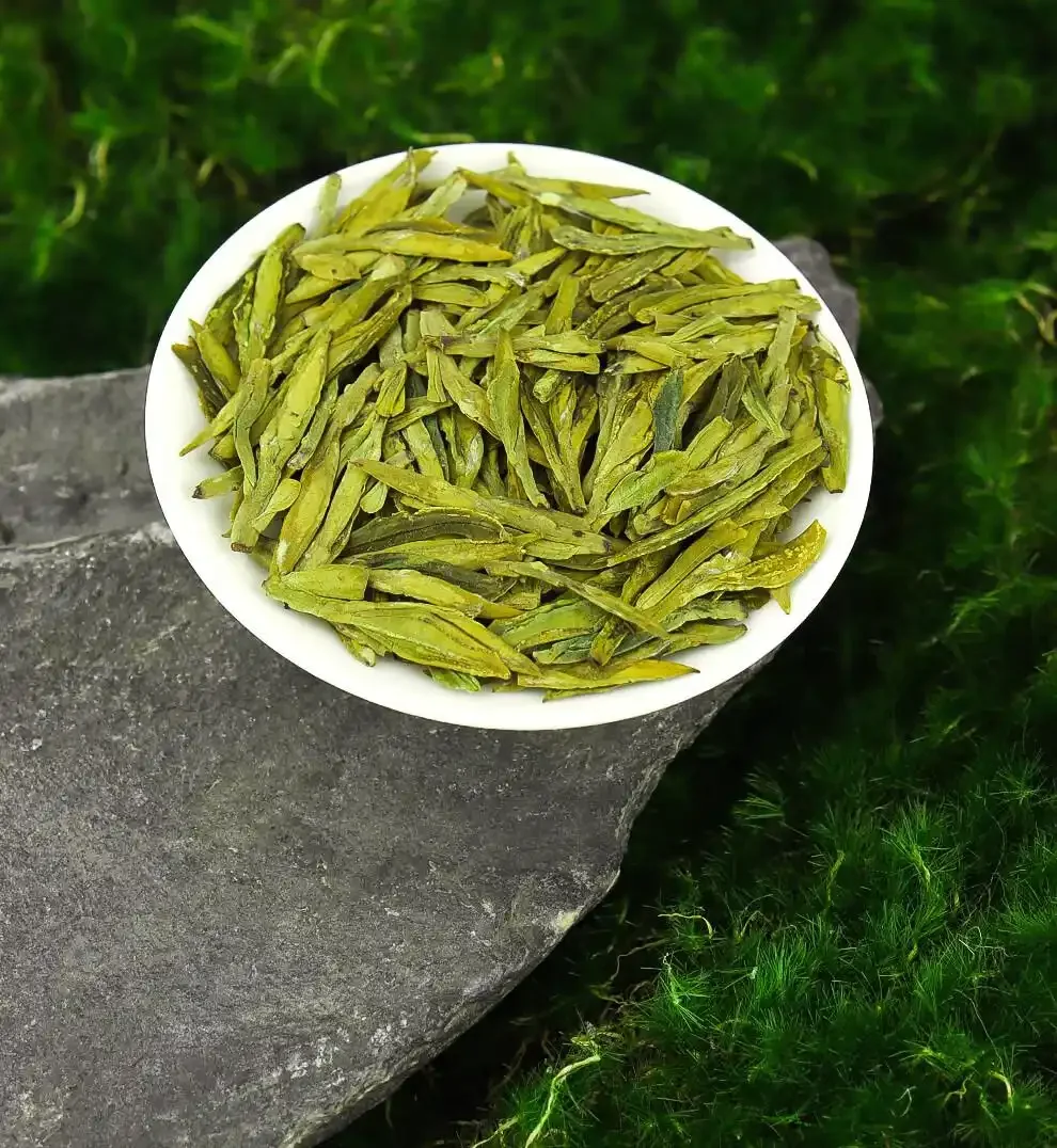 Flat Longjing green tea leaves arranged on a white plate