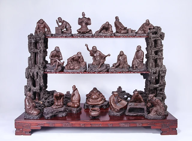 18体のアーハト陶製像が3段の台の上に展示されています