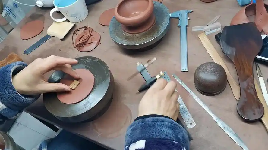 Ton Scheiben, Messwerkzeuge und teekanne Teile auf einer Yixing Keramikwerkbank
