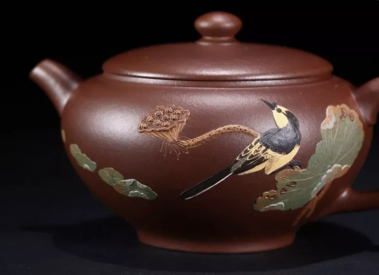 Rouge-brun théière avec des motifs colorés de oiseaux, de feuilles de lotus et de graines.