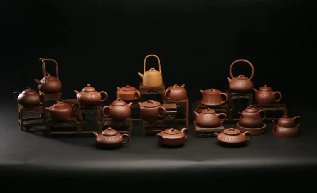 छोटे स्टैण्डों पर विभिन्न आकार के मिट्टी teapotस्लैबों का संग्रह