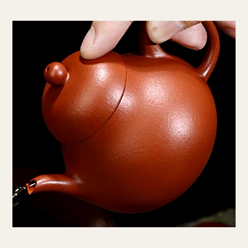 Pear-shaped Zhuni Yixing teapot tilted during a pour