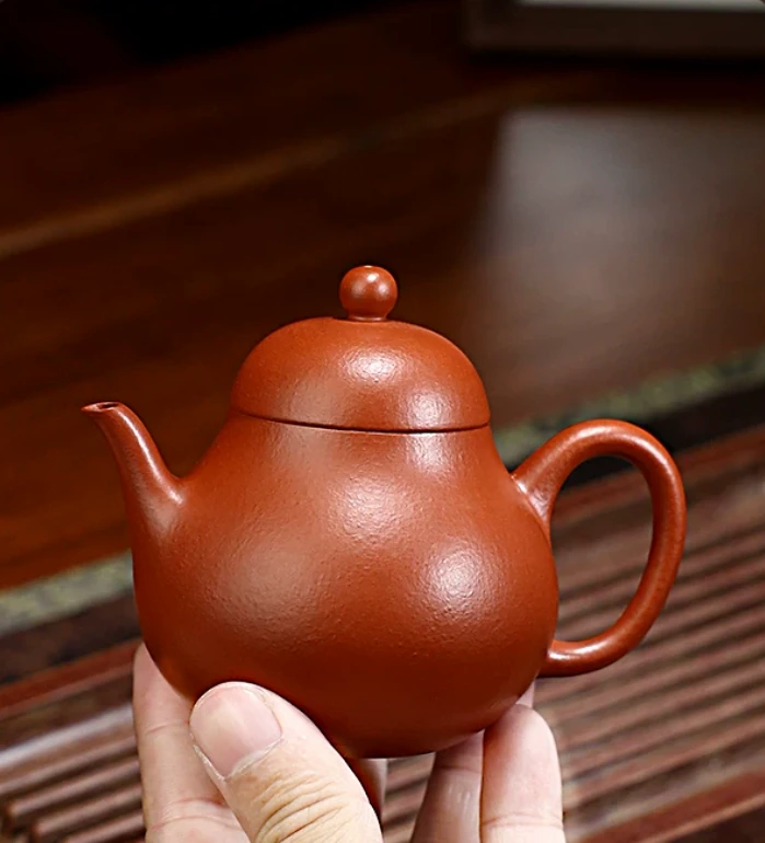 Pear-shaped Zhu Ni teapot held in a hand to show its size