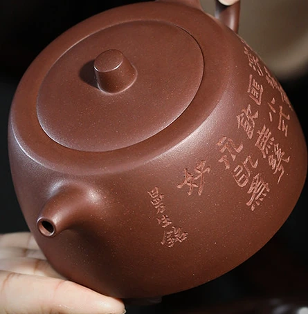 Low Jinglan teapot held in the hands