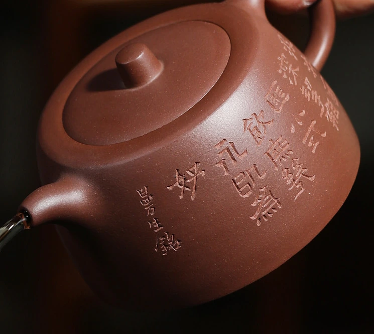 Engraved Low Jinglan teapot tilted during pouring