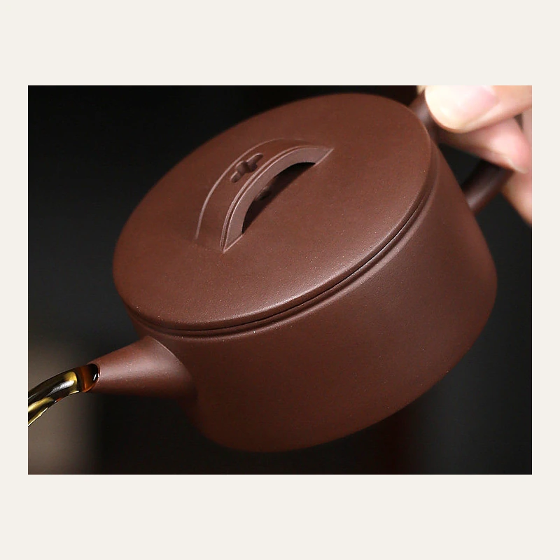 Hanwa teapot tilted during a pour, showing its spout and lid